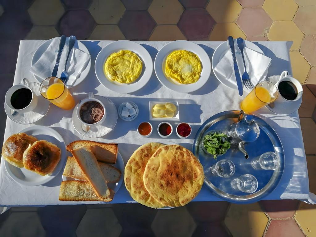 une table garnie d'assiettes de nourriture et de boissons pour le petit-déjeuner dans l'établissement Riad Le Grand Large, à Essaouira