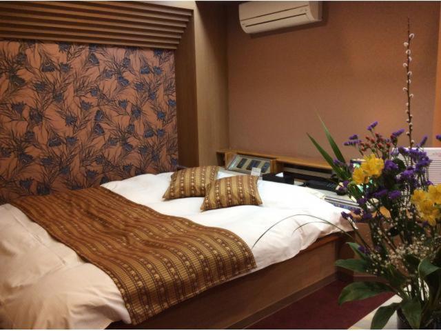 - une chambre avec un grand lit et une composition florale dans l'établissement HOTEL GEN 猪名川店, à Yamashita 9 autres photos