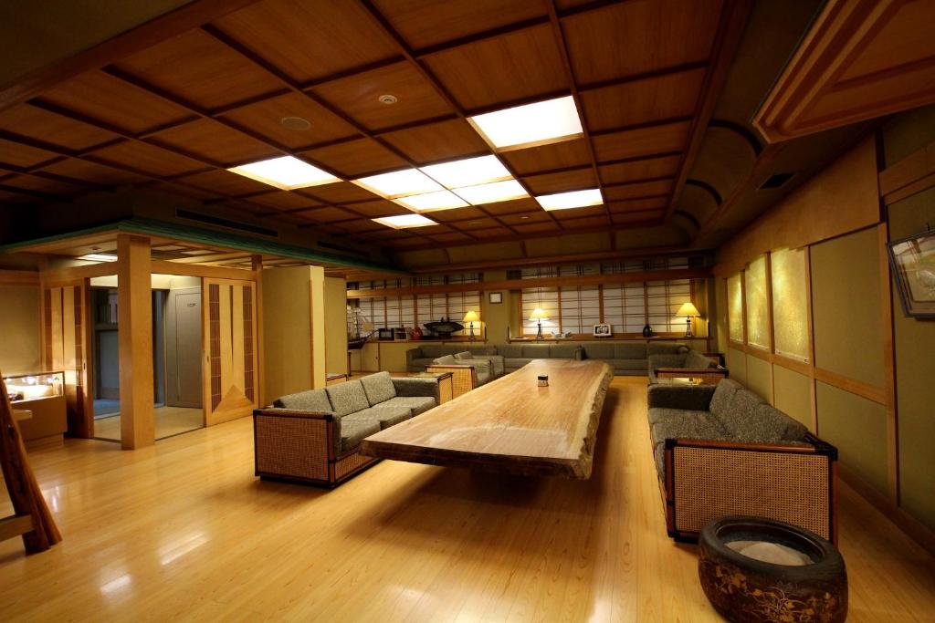 un grand salon avec une table et des canapés dans l'établissement Wakamatsu Hot Spring Resort, à Hakodate