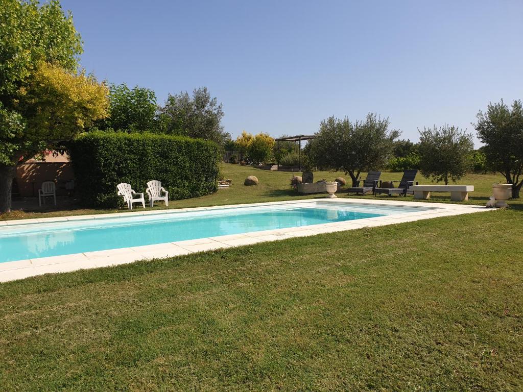 - une piscine dans une cour avec 2 chaises longues dans l'établissement Gîte de la fontaine, à Buisson