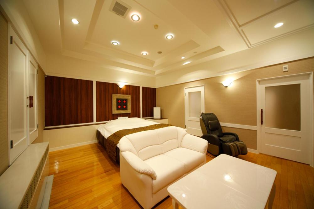 une chambre avec un lit, un canapé et une chaise dans l'établissement ホテルシエル静岡店 静岡インター - レジャーホテル -, à Shizuoka