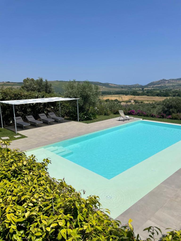 une piscine bleue avec des chaises et une vue dans l'établissement Tenuta di Quaranta, à Amaroni