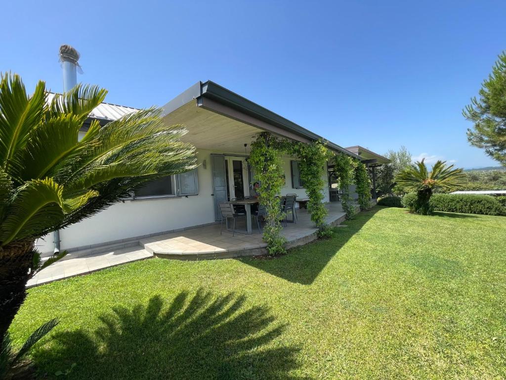 une petite maison blanche avec une cour gazonnée dans l'établissement Tenuta di Quaranta, à Amaroni