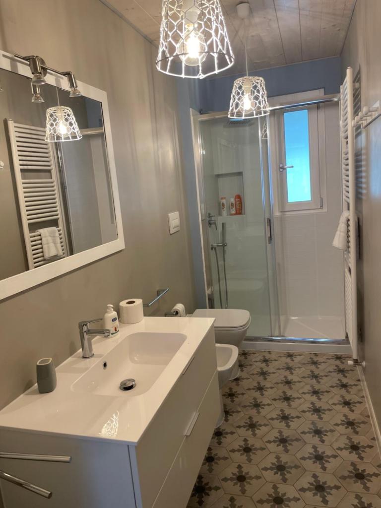 La salle de bains est pourvue d'un lavabo, de toilettes et de deux lumières. dans l'établissement Tenuta di Quaranta, à Amaroni