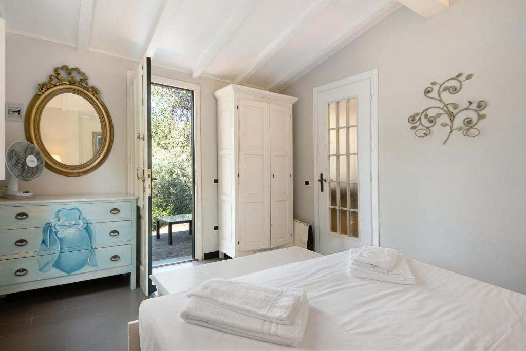 une chambre blanche avec un lit et un miroir dans l'établissement Villa Mesco, à Levanto