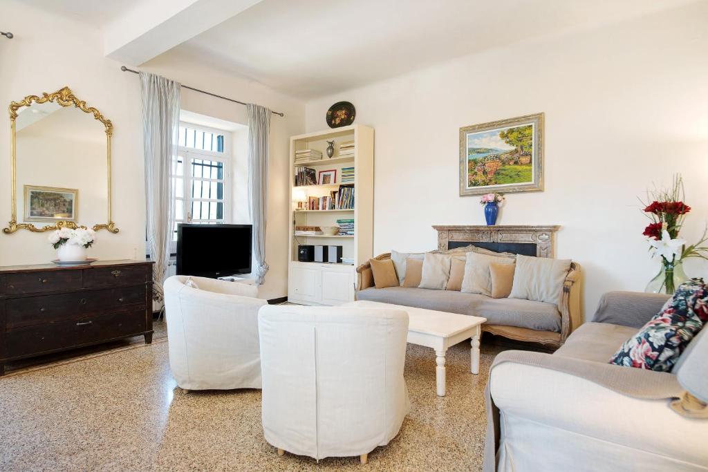Il comprend un salon doté d'un mobilier blanc et d'une télévision. dans l'établissement Villa Mesco, à Levanto