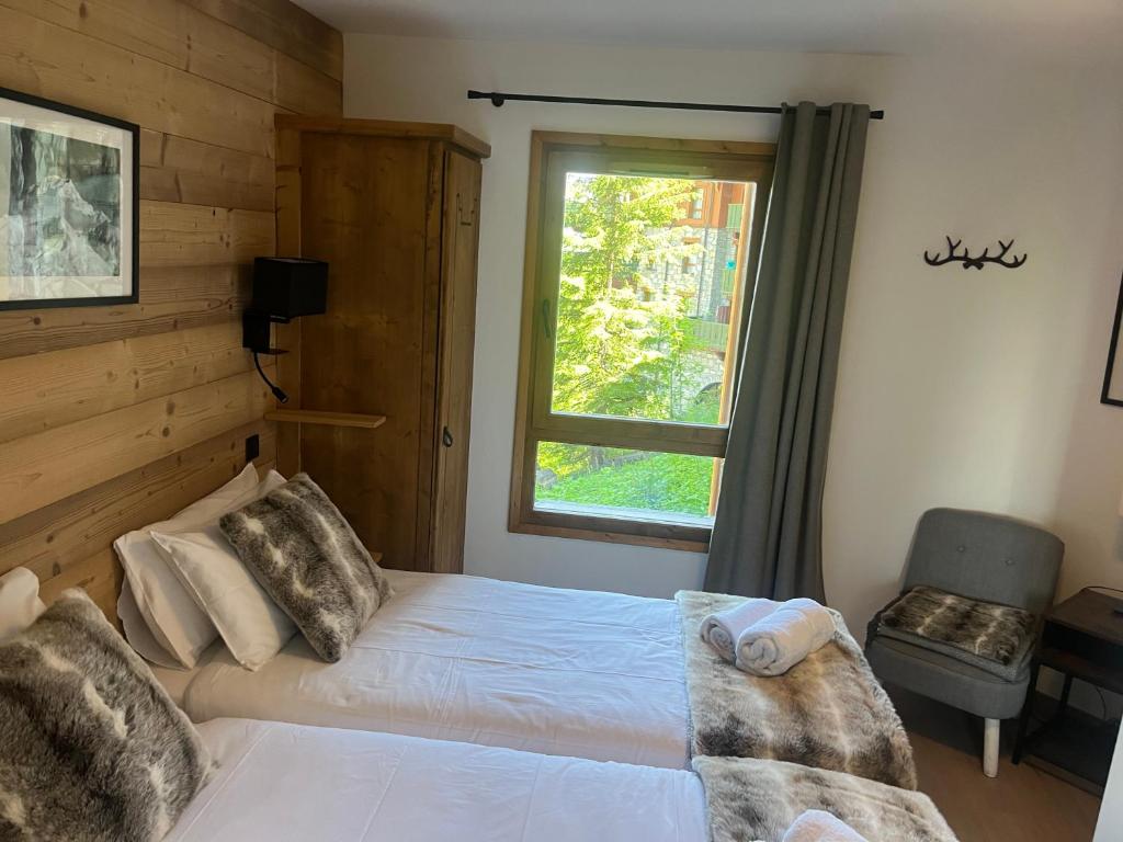 une chambre avec un lit et une fenêtre dans l'établissement Arc 1950 Ski in Ski out and Spa- Newly refurbished 153 Sources De Marie- 2 bedroom , 2 bathroom-Sleeps 4-6, Mont Blanc view from every window, Free WiFi, à Arc 1950