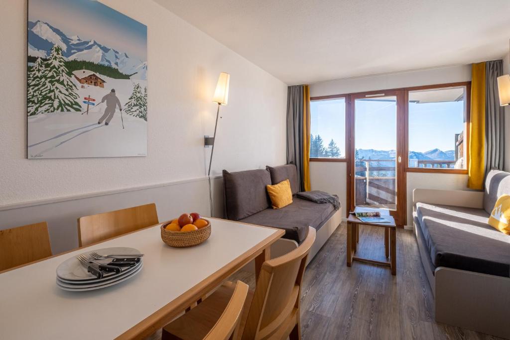 un salon avec une table et un canapé dans l'établissement Résidence Pierre & Vacances Saskia Falaise, à Avoriaz