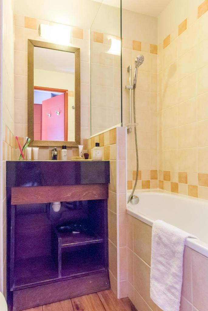 une salle de bain avec un lavabo, une baignoire et un miroir dans l'établissement Résidence Pierre & Vacances Saskia Falaise, à Avoriaz 37 autres photos