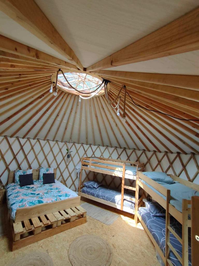 - une chambre avec 2 lits dans une yourte dans l'établissement la Yourte des Bibis, à Fréland