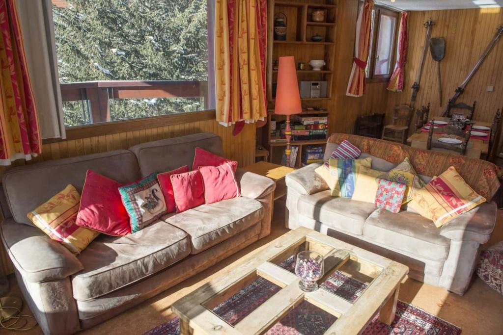 un salon avec deux canapés et une table basse dans l'établissement Charming Ski Apartment in Courchevel 1850, à Courchevel
