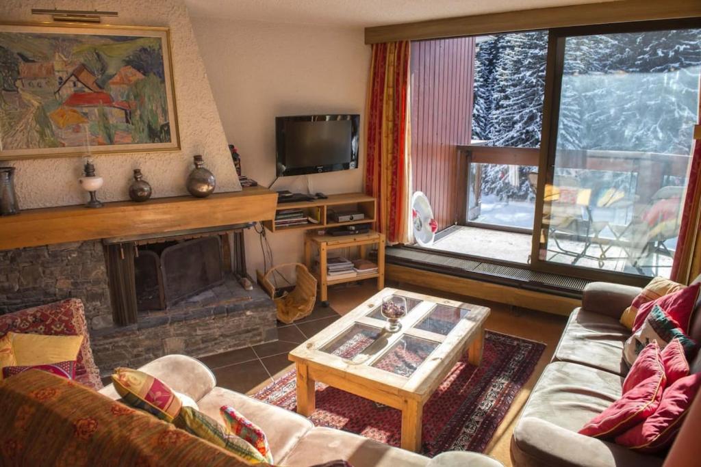un salon avec un canapé et une cheminée dans l'établissement Charming Ski Apartment in Courchevel 1850, à Courchevel