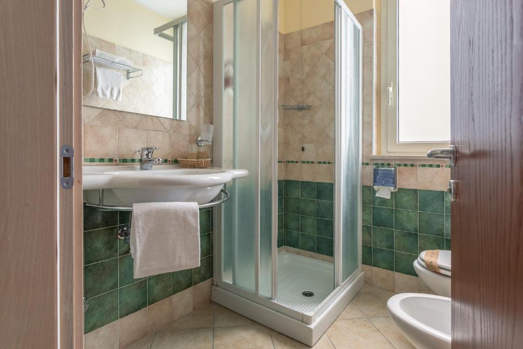 une salle de bain avec un lavabo, une douche et des toilettes dans l'établissement Hotel Prestige, à Montesilvano