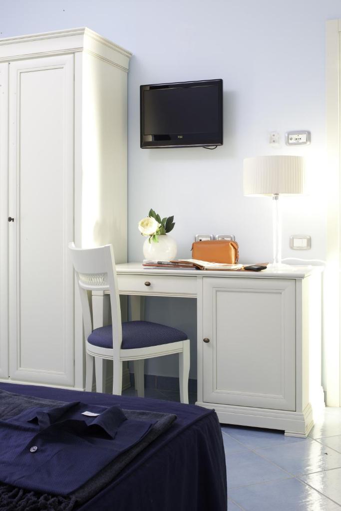 un bureau blanc avec une chaise et une télévision au mur dans l'établissement Parco Dei Principi, à Paestum