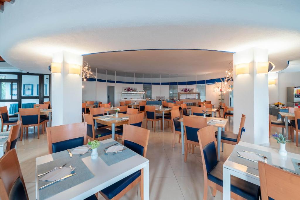 un restaurant avec des tables et des chaises ainsi qu'une salle à manger dans l'établissement Hotel Mira, à Peschici