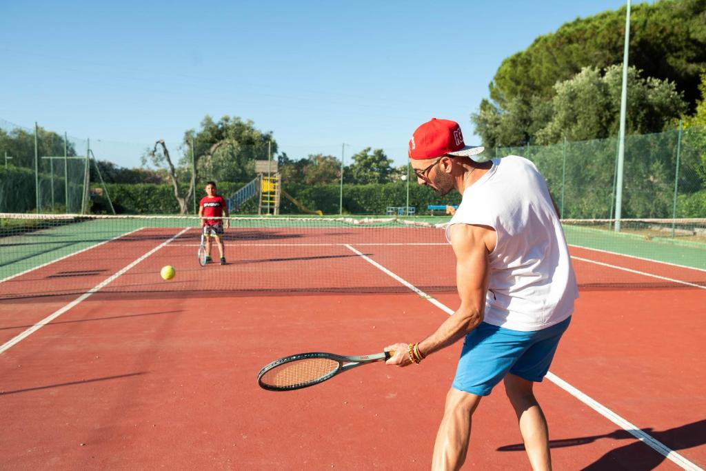 deux hommes jouant au tennis sur un court de tennis dans l'établissement Hotel Mira, à Peschici