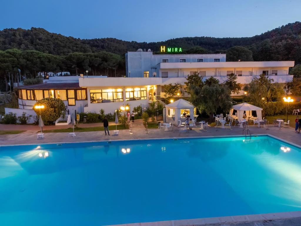 un hôtel avec une grande piscine la nuit dans l'établissement Hotel Mira, à Peschici