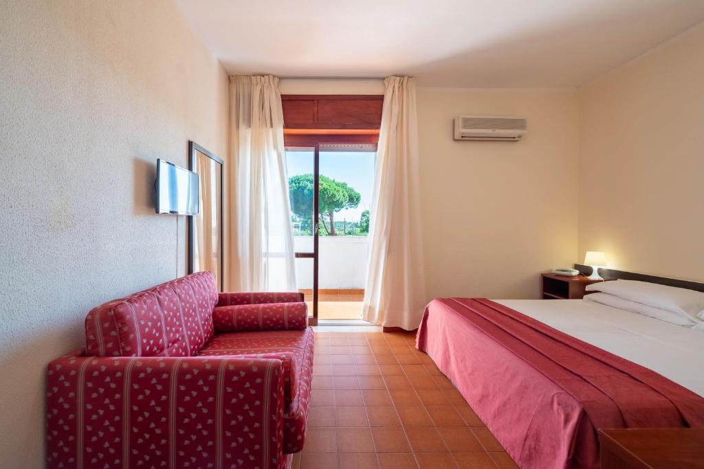 une chambre avec un lit, une chaise et une fenêtre dans l'établissement Hotel Mira, à Peschici