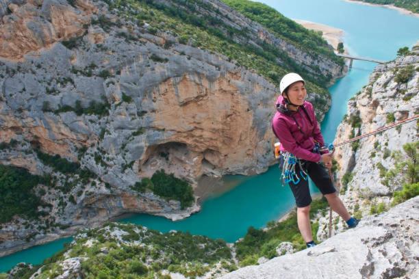 une femme debout sur une falaise avec une corde devant une rivière dans l'établissement CAMPING 3* / GORGES DU VERDON / POUR 2 PERS/ LAVANDE / ACTIVITÉS/A 2 MN DU LAC DE STE CROIXI, à Sainte-Croix-de-Verdon