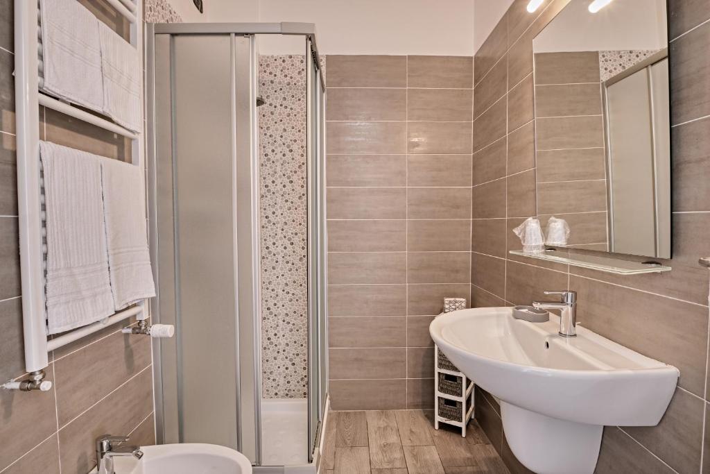 une salle de bain avec un lavabo, des toilettes et une douche dans l'établissement Hotel Astoria, à Bordighera