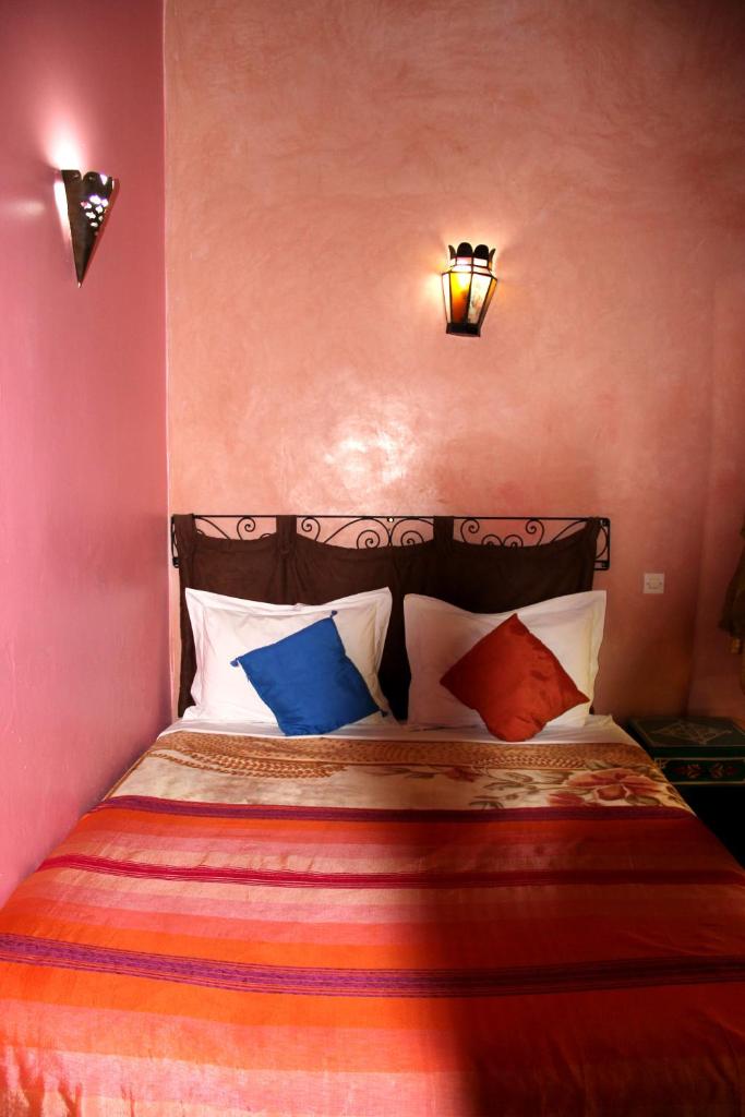 - une chambre avec un lit et des oreillers colorés dans l'établissement Dar Aida, à Rabat