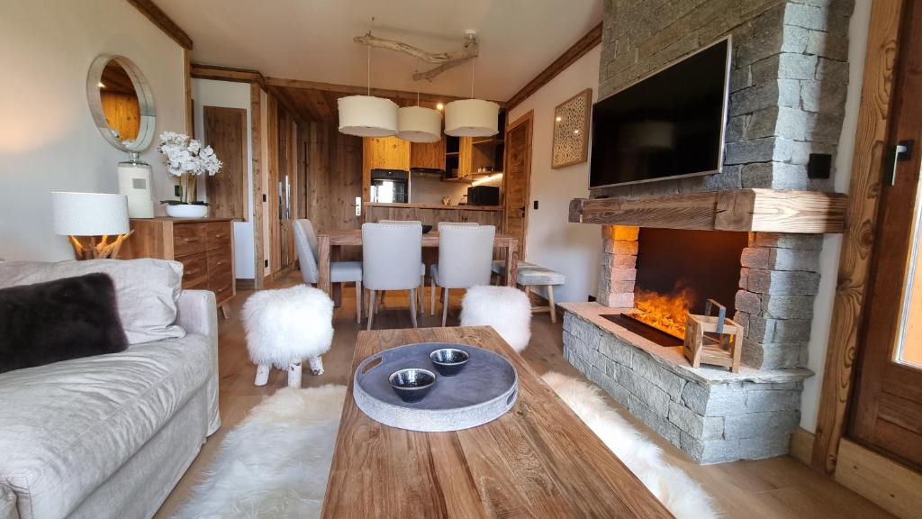 un salon avec un canapé et une cheminée dans l'établissement Arcs 1950 Appartement Luxe type chalet 5 à 7 personnes Vue imprenable sur le Montblanc skis aux pieds, à Arc 1950