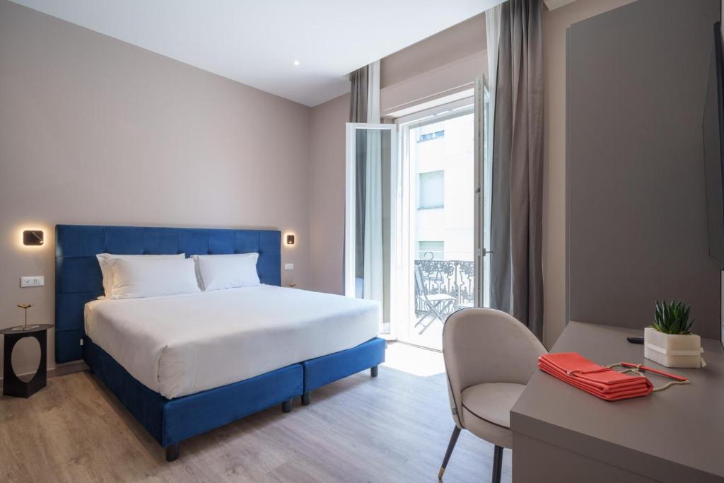 une chambre avec un lit, un bureau et une fenêtre dans l'établissement Vi Suites, à Viareggio 227 autres photos