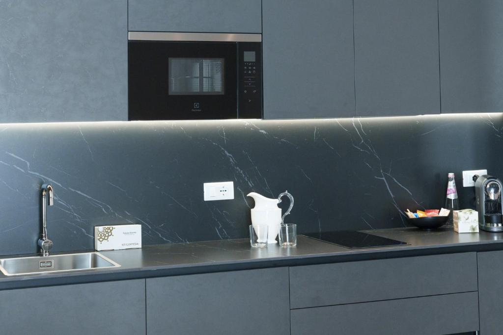 une cuisine avec un comptoir avec un évier et un micro-ondes dans l'établissement Vi Suites, à Viareggio