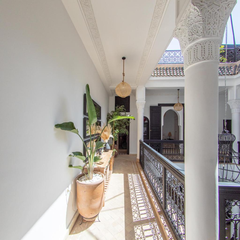 un couloir d'une maison avec des chaises et des plantes dans l'établissement RIAD DAR C, à Marrakech