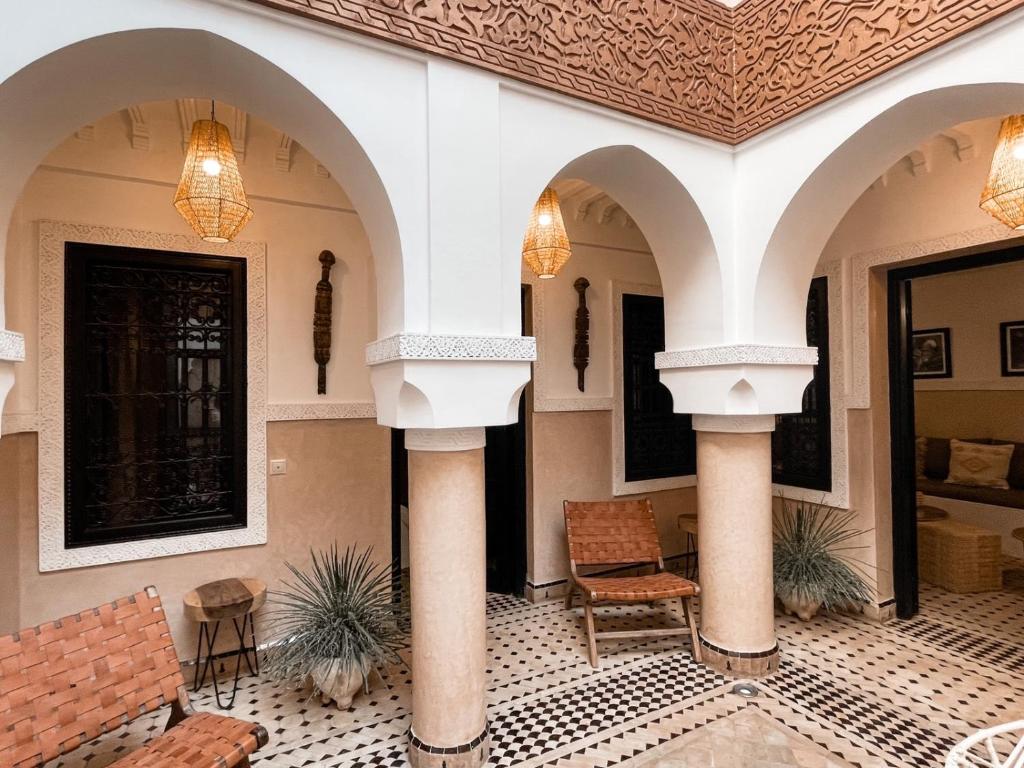 un hall avec des colonnes et des chaises dans un bâtiment dans l'établissement Riad Comme chez soi Marrakech by Louhou collection, à Marrakech