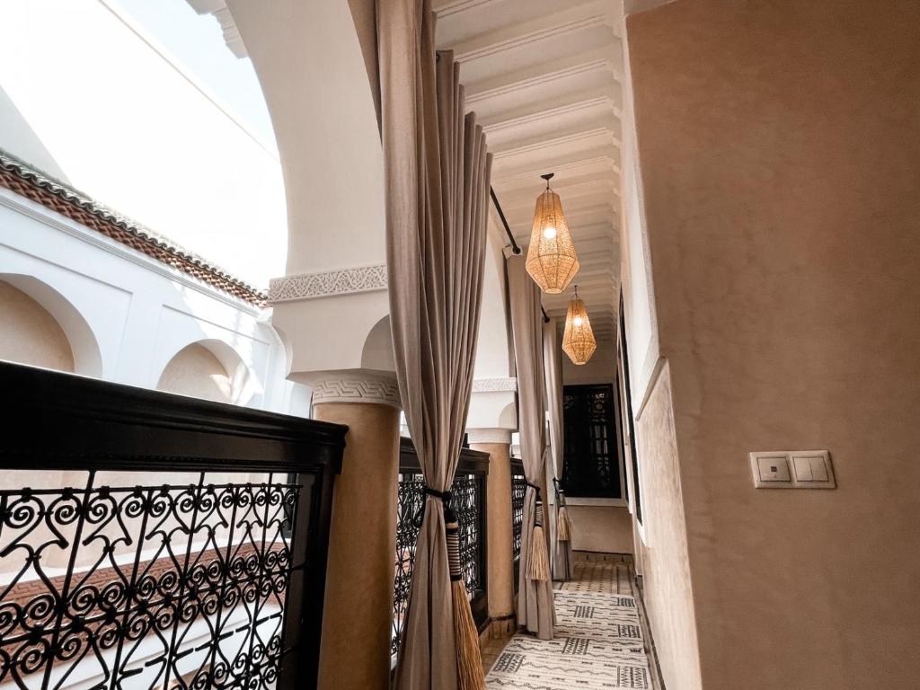 un couloir d'un immeuble avec une porte et des lustres dans l'établissement Riad Comme chez soi Marrakech by Louhou collection, à Marrakech 8 autres photos