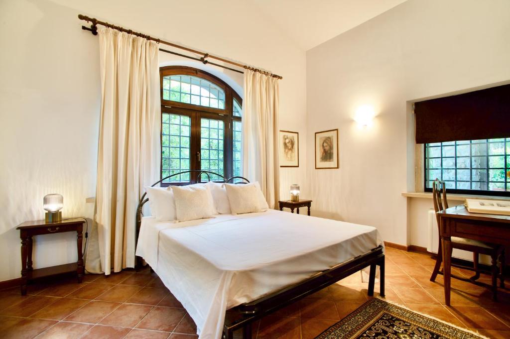 une chambre avec un lit avec des draps blancs et une fenêtre dans l'établissement Villa del Nibbio luxury villa with pool in Umbria, à Ficulle