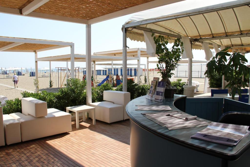 un restaurant avec une table et des chaises sur une terrasse dans l'établissement Grand Hotel Terme, à Margherita di Savoia