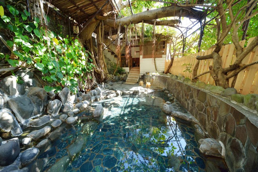 une piscine d'eau avec un mur en pierre et des escaliers dans l'établissement Izu Atagawa Onsen Miharuya, à Higashiizu