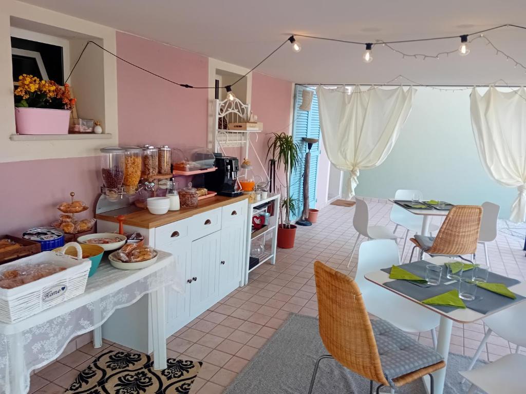 une cuisine avec des murs roses, une table et des chaises dans l'établissement B&B Tra colline marchigiane - sauna e piscina, à San Giorgio di Pesaro
