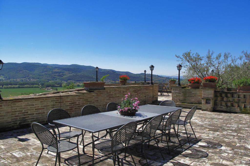 une table et des chaises assises sur une terrasse dans l'établissement Villa Del Colle - Happy Rentals, à Torgiano