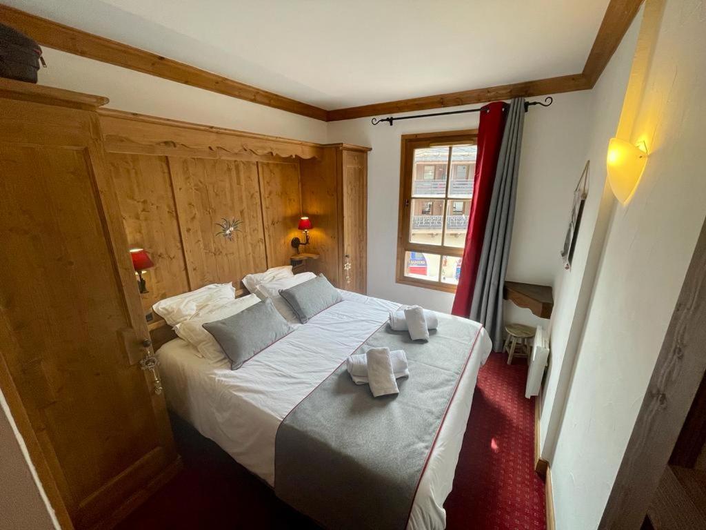 une chambre avec un grand lit avec des serviettes dessus dans l'établissement Arc 1950 - Appt 2CH - 6 pers - Rés 5* luxe - Piscine, sauna, hamman, jacuzzi - Classé 5 cristaux Paradiski, à Arc 1950 27 autres photos