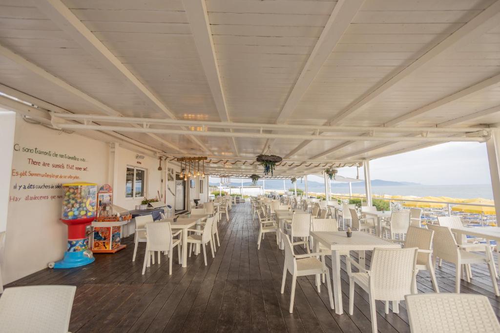 un restaurant avec des tables et des chaises blanches et une vue dans l'établissement Hotel Le Palme, à Paestum