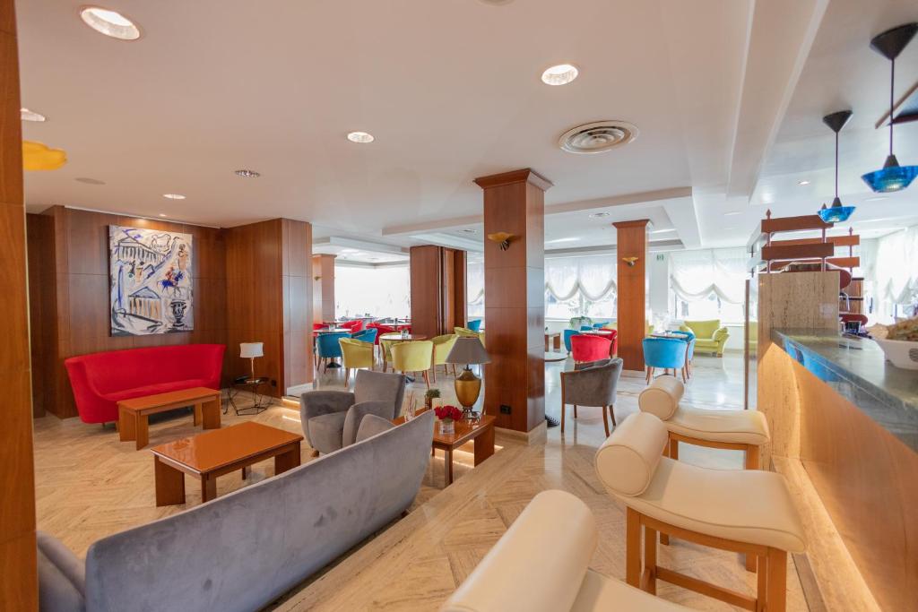 un hall avec des chaises et des tables dans un bâtiment dans l'établissement Hotel Le Palme, à Paestum