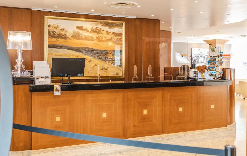 un hall d'entrée avec un bureau de réception avec un grand tableau dans l'établissement Hotel Le Palme, à Paestum 242 autres photos