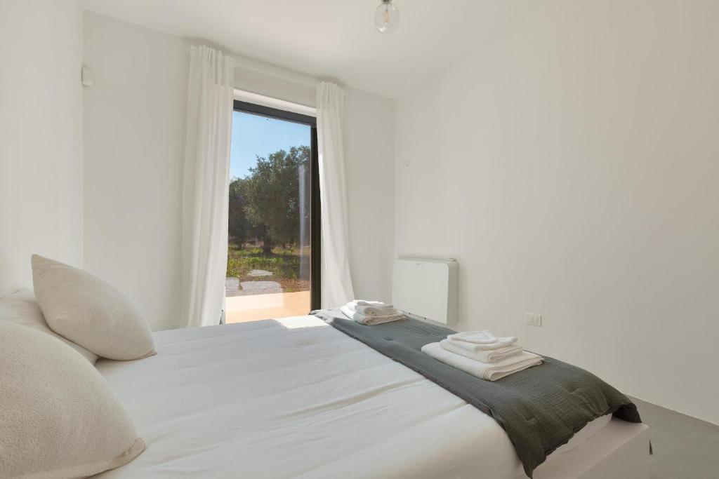 une chambre blanche avec un grand lit avec une fenêtre dans l'établissement Villa Sylvia by Perle di Puglia, à San Vito dei Normanni 40 autres photos