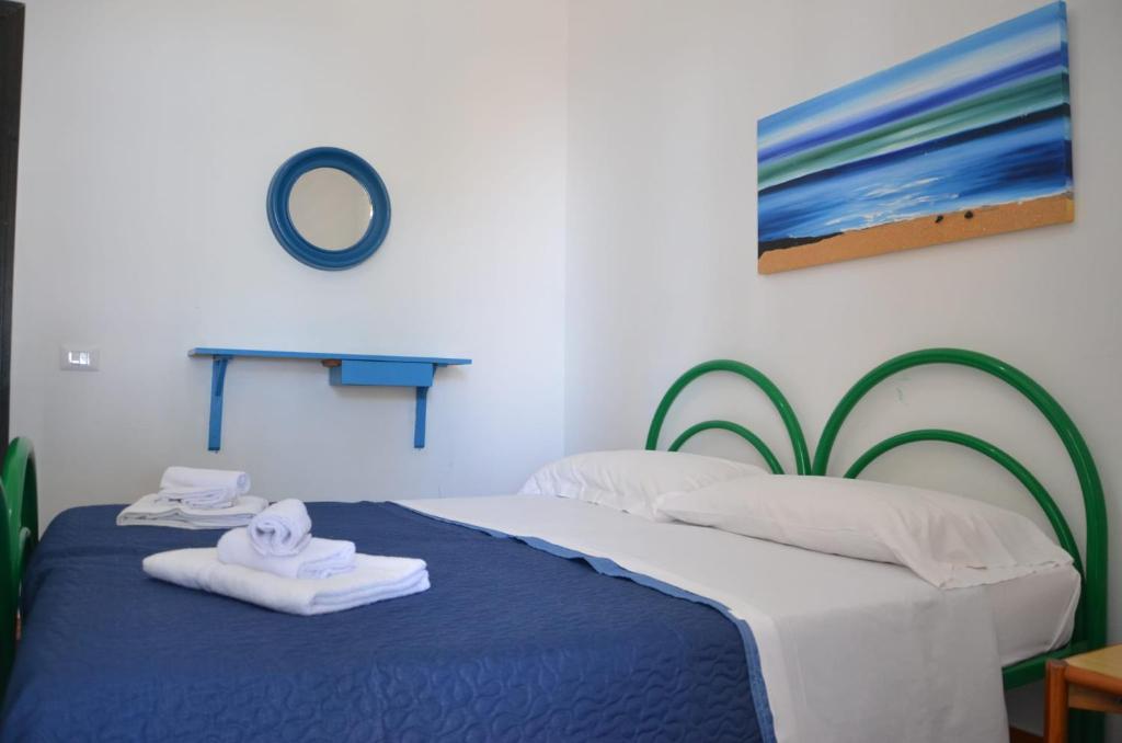 une chambre avec deux lits avec des serviettes dessus dans l'établissement Villa Teti - Sicilia, à Campofelice di Roccella 146 autres photos