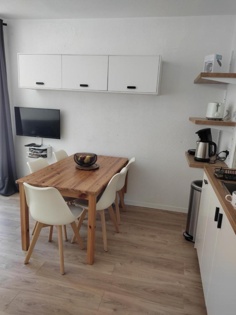 une cuisine et une salle à manger avec une table et des chaises en bois dans l'établissement Très beau T2 rénové pour 7 personnes maximum à Barèges, à Barèges