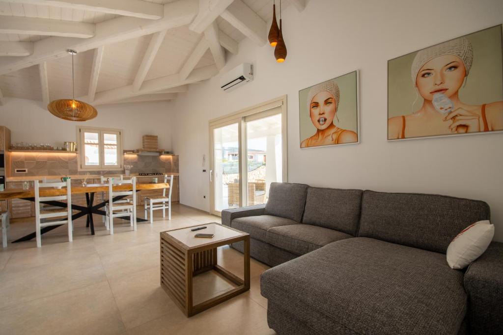 un salon avec un canapé et une salle à manger dans l'établissement Capannizza Villas, à Budoni