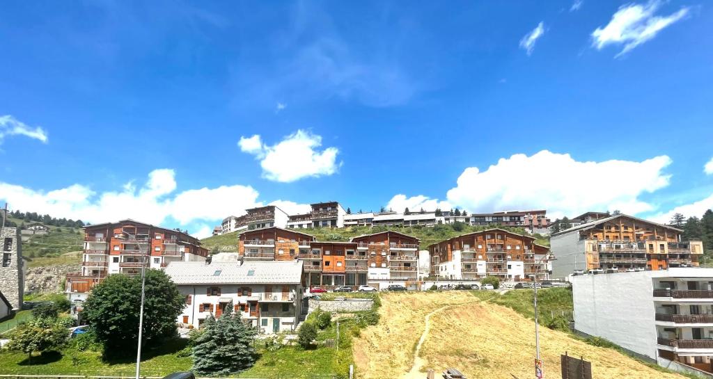un groupe d'immeubles d'appartements au sommet d'une colline dans l'établissement Confort Moderne à Valberg - Terrasse avec Vue Panoramique 100 m des Pistes, à Valberg