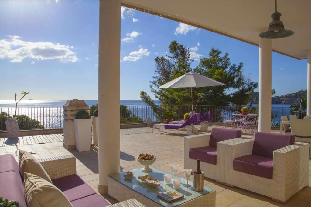d'une terrasse avec mobilier violet et vue sur l'océan. dans l'établissement Taormina Villa Oasis Residence, à Taormine