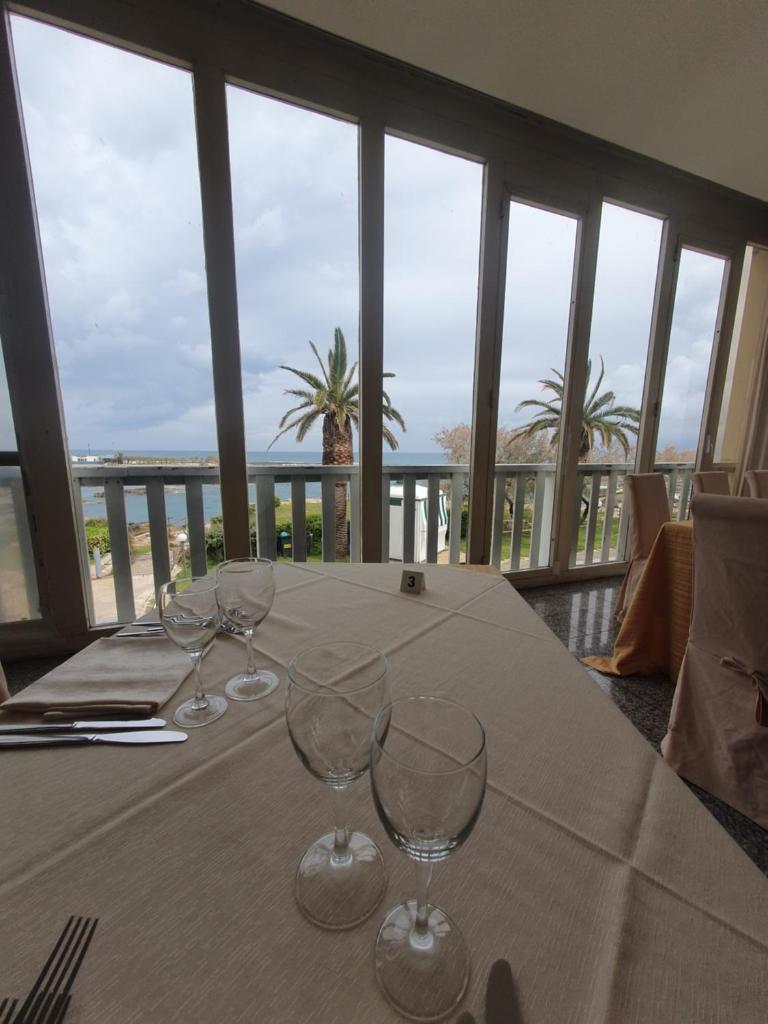 - une table avec des verres à vin au-dessus du balcon dans l'établissement Hotel Il Timone, à Specchiolla 2 autres photos