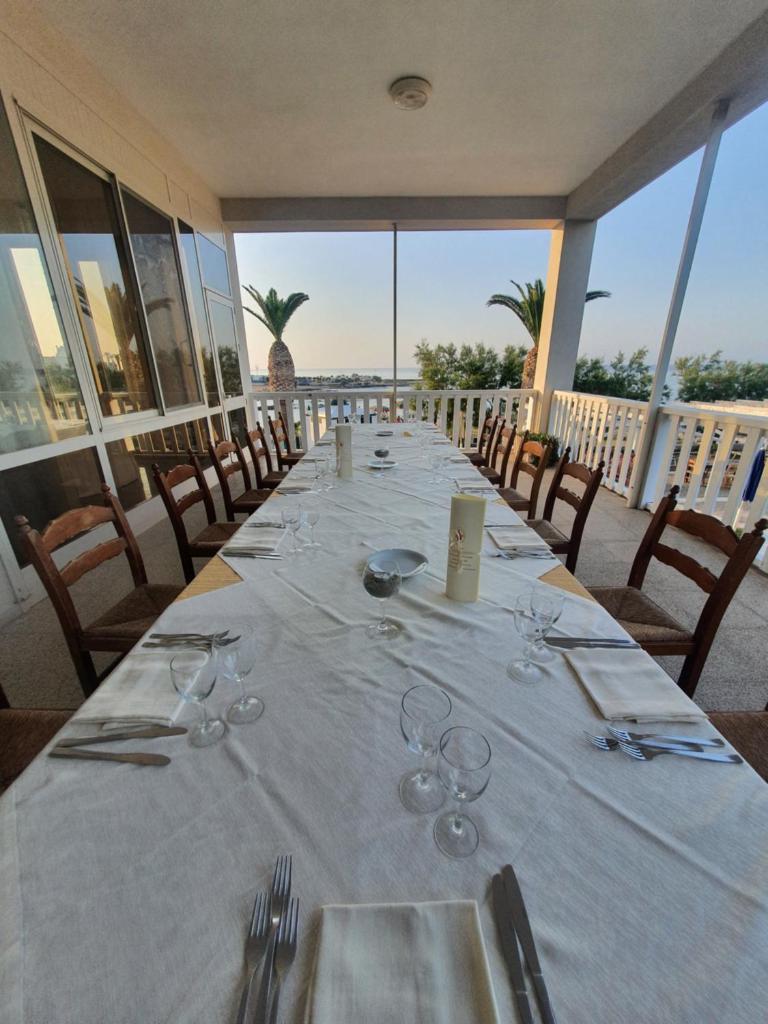 - une longue table avec des verres à vin sur le balcon dans l'établissement Hotel Il Timone, à Specchiolla
