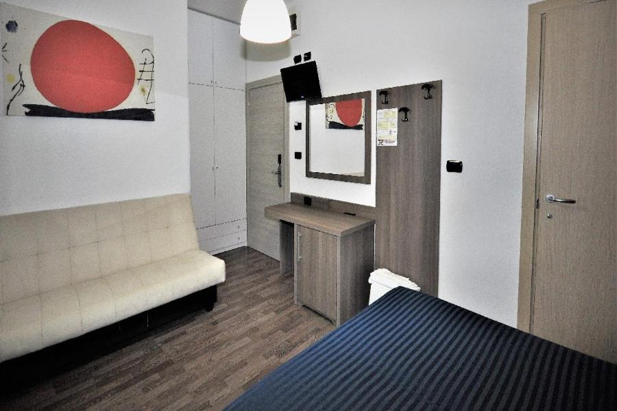 Cette chambre comprend un lit et un miroir mural. dans l'établissement Hotel Miramare Dipendenza, à Pineto