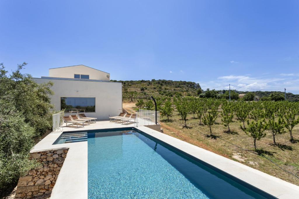 une villa avec piscine face à un vignoble dans l'établissement Villa Mandorlo - IsulaTravel, à Noto